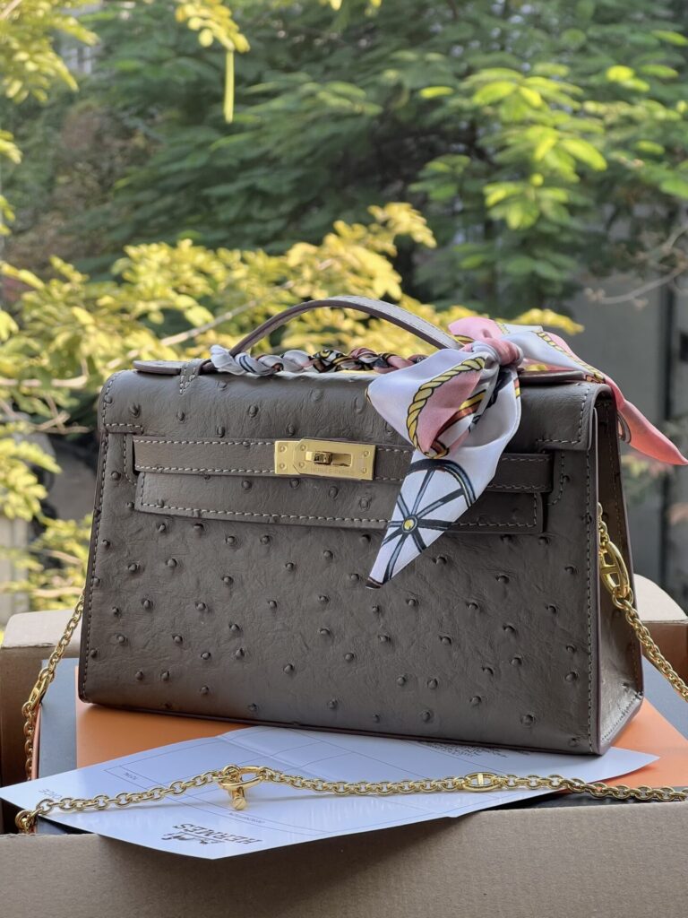 TÚI XÁCH HM KELLY POCHETTE VÂN DA ĐÀ ĐIỂU SIÊU CẤP TAG VÀNG MÀU NÂU ĐẤT