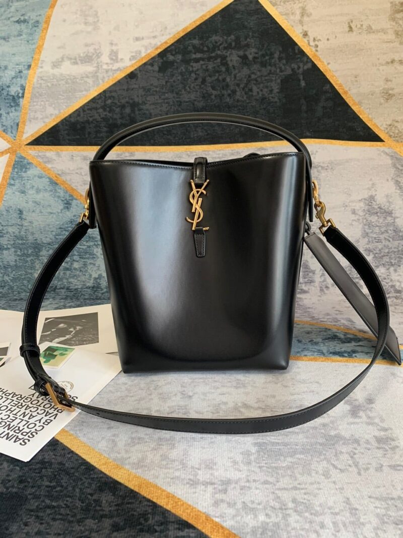 BUCKET BAG FEATURING THE CASSANDRE HOOK CLOSURE, TOP HANDLE AND AN ADJUSTABLE AND DETACHABLE SHOULDER STRAP. SUEDE LINING LIGHT BRONZE-TONED METAL HARDWARE CASSANDRE HOOK CLOSURE ONE ZIPPED POUCH FOUR METAL FEET DIMENSIONS: 20 X 25 X 16 CM HANDLE DROP: 9 CM STRAP DROP: 40 CM 100% CALFSKIN LEATHER